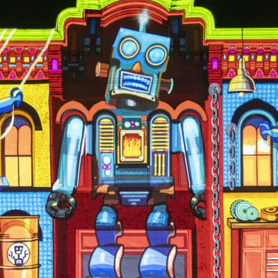 Projected robot artwork on a building during the Peg Johnston Living Lights Project at LUMA