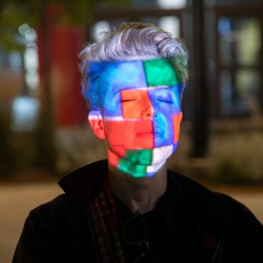 Portrait of a person with colorful projected squares across their face at LUMA